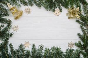 Christmas fir tree with decoration and glitters on wooden background. Christmas background on the white wooden desk photo