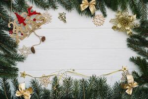 Christmas fir tree with decoration and glitters on wooden background. Christmas background on the white wooden desk photo