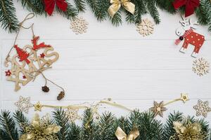 Christmas fir tree with decoration and glitters on wooden background. Christmas background on the white wooden desk photo