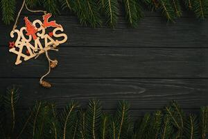 Christmas or New Year dark wooden background, Xmas black board framed with season decorations, space for a text, view from above photo