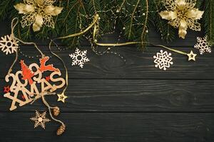 Christmas or New Year dark wooden background, Xmas black board framed with season decorations, space for a text, view from above photo