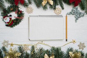 Christmas fir tree with decoration and glitters on wooden background. Christmas background on the white wooden desk photo