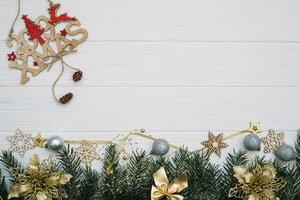 Christmas fir tree with decoration and glitters on wooden background. Christmas background on the white wooden desk photo