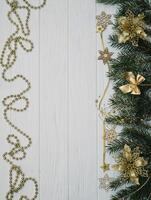 Christmas fir tree with decoration and glitters on wooden background. Christmas background on the white wooden desk photo