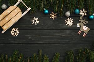 Christmas or New Year dark wooden background, Xmas black board framed with season decorations, space for a text, view from above photo