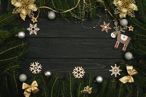 Christmas or New Year dark wooden background, Xmas black board framed with season decorations, space for a text, view from above photo