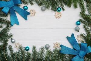 Christmas fir tree with decoration and glitters on wooden background. Christmas background on the white wooden desk photo