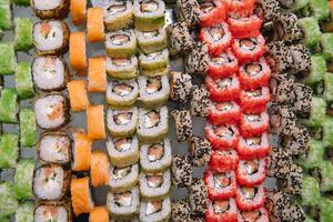 Decorated catering banquet table with different sushi rolls and nigiri sushi plate assortment on a party. photo