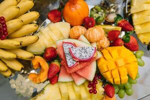 Fresh organic fruits background. Healthy eating concept. Fresh, exotic, organic fruits, light snacks in a plate on a buffet table photo