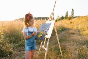 education, school, art and painitng concept - little student girl painting picture photo