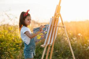 educación, escuela, Arte y doloroso concepto - pequeño estudiante niña pintura fotografía. foto