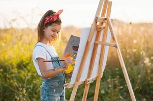 pequeño niña es pintura imagen al aire libre. foto