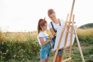 Young mother and her daughter have fun, mother's Day. smiling mother with beautiful daughter draws nature photo