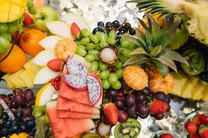 Fresh organic fruits background. Healthy eating concept. Fresh, exotic, organic fruits, light snacks in a plate on a buffet table photo