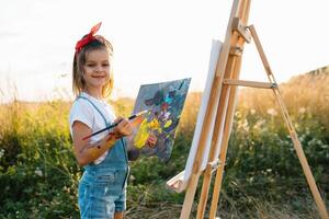 Little Girl Is Painting Picture Outdoors photo