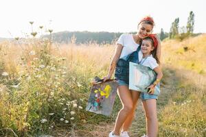 Sunny nature, mom and daughter paint a picture in a park , painting a Little Child, Child Creativity. Mother's Day. photo