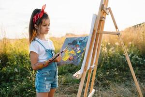 Little Girl Is Painting Picture Outdoors photo