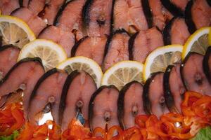 Elegant Restaurant Plate with Fish Delicacies Top View. Smoked Butter Fish with Lemon. smoked fish with lemon buffet. photo