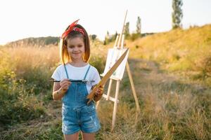 Little Girl Is Painting Picture Outdoors. photo