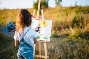 pequeño niña es pintura imagen al aire libre. foto