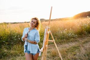 Pretty talented female painter painting on easel, making colorful sketches, creating marine landscape. Beautiful female artist painting with watercolor paints. Creativity and imagination concept photo