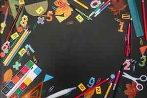 Back to school concept. School and office supplies on blackboard background. Flat lay with copy space photo