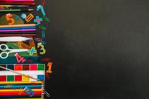 Back to school concept. School and office supplies on blackboard background. Flat lay with copy space photo