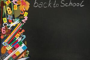 Back to school concept. School and office supplies on blackboard background. Flat lay with copy space photo