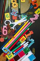 Back to school concept. School and office supplies on blackboard background. Flat lay with copy space photo