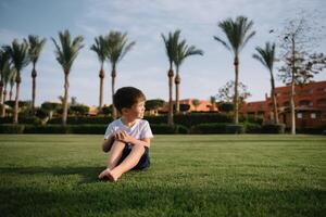 Cute boy runs on a green lawn playing catch-up in nature on a Sunny day. photo