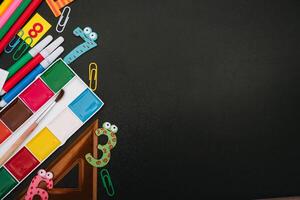 Back to school concept. School and office supplies on blackboard background. Flat lay with copy space photo