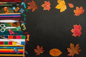 Back to school concept. School and office supplies on blackboard background. Flat lay with copy space photo