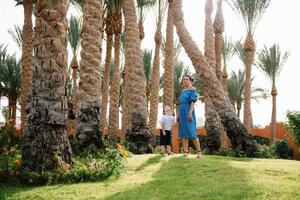 Stylish mother and handsome son having fun on a green lawn. Happy family concept. Beauty nature scene with family outdoor lifestyle. Happy family resting together. Mothers day photo