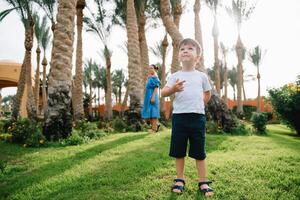 Stylish mother and handsome son having fun on a green lawn. Happy family concept. Beauty nature scene with family outdoor lifestyle. Happy family resting together. Mothers day photo