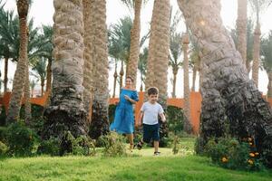 Stylish mother and handsome son having fun on a green lawn. Happy family concept. Beauty nature scene with family outdoor lifestyle. Happy family resting together. Mothers day photo