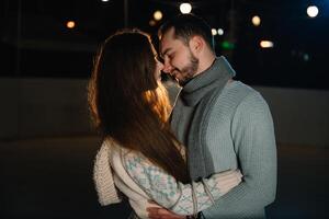 Happy attractive couple in a christmas market at night. Beautiful bokeh lights background. photo