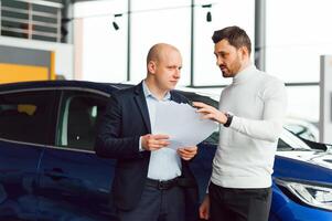 Salesperson selling cars at car dealership photo