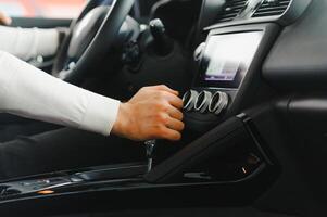 Male hand on the shift lever of the transmission in the car photo