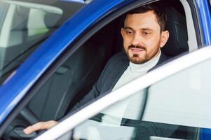 atractivo elegante contento hombre en bueno coche foto