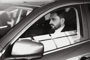 Handsome elegant serious man drives a car photo