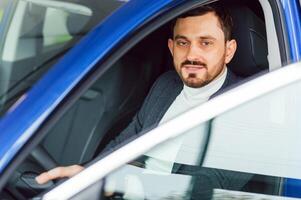 Handsome elegant serious man drives a car photo