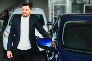 Handsome man choosing a car in a show room photo