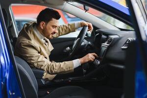 Attractive elegant happy man in good car photo