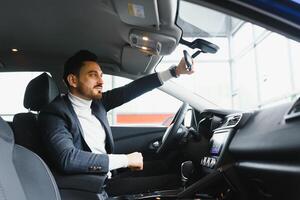 atractivo elegante contento hombre en bueno coche foto