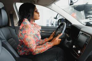 happy african woman driving a new car photo