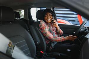 Beautiful black woman doing selfie in the car. Lips young woman taking selfie picture with smart phone camera outdoors in car photo