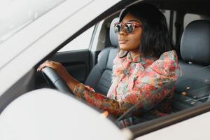 happy african woman driving a new car photo