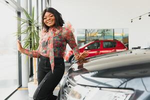 Woman buying the car. Lady in a car salon. Elegant black girl. woman in car salon photo