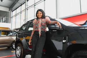 Woman buying the car. Lady in a car salon. Elegant black girl. woman in car salon photo