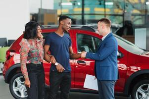 young african couple buying new car at dealership photo